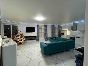 阿让特伊appartement luxueux 70m2, 2 chambres的一间带蓝色沙发的客厅和一间厨房