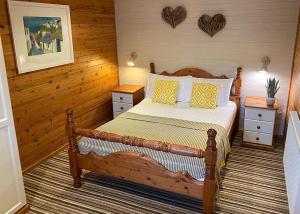 StrattonIvyleaf Combe Lodges的一间卧室配有黄色和白色枕头的床