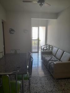 瓜拉派瑞Ap 300m praia do morro的客厅配有沙发和桌子