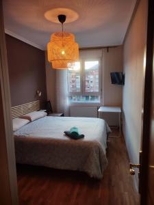 奥维多Alberto Astur Habitaciones privadas màs cocina compartida的一间卧室,配有一张床,上面有帽子