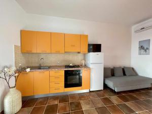 兰佩杜萨Dammusi cala croce的一间厨房,内配橙色橱柜和一张沙发