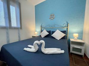 兰佩杜萨Dammusi cala croce的两条毛巾,形状像天鹅,坐在床上