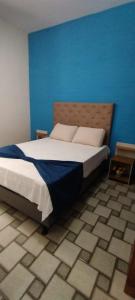 卡波布里奥Pousada do Luar Cabo Frio的一间卧室设有一张蓝色墙壁的大床