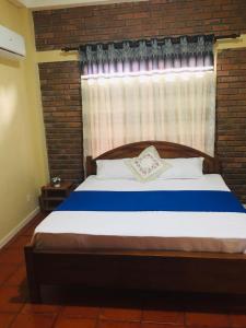 KandanaSerene Inn Kandana的一间卧室配有一张砖墙床