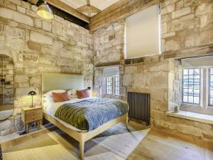 考文垂Swanswell Gate的卧室配有一张石墙床