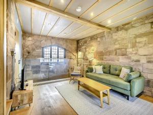 考文垂Swanswell Gate的客厅设有绿色沙发和石墙