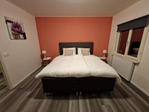 WichmondB&B gewoon Prins的一间卧室配有一张带橙色墙壁的大床