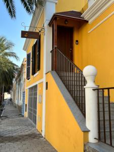 明德卢Orietta Residencial的一条黄色的建筑,在街道旁设有楼梯