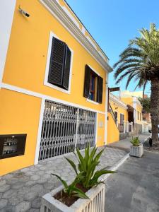 明德卢Orietta Residencial的黄色的建筑,有门和棕榈树