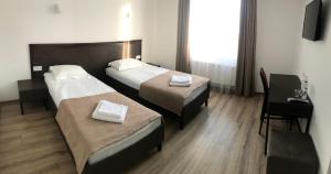 利沃夫Leo Rooms的酒店客房配有两张床和一张书桌