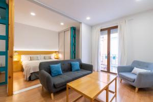 塞维利亚Locksmith Apartment -Wifi- Park Option的客厅配有床、沙发和桌子
