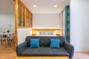 塞维利亚Locksmith Apartment -Wifi- Park Option的一间卧室配有一张床和一张带蓝色枕头的沙发