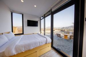 SharīyahGo Camp Mountain Nature Lodge مخيم الطبيعة الجبلية的一间卧室设有一张床和一个大窗户