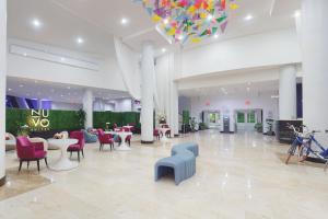 迈阿密Nuvo Suites Hotel - Miami Doral的大堂设有桌椅和吊灯。