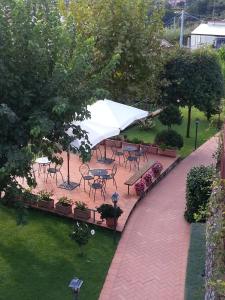 特拉蒙蒂法比勒加比亚尼酒店的庭院配有桌椅和白色遮阳伞。