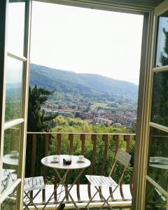 贝加莫B&B Dimora Delle Donnole Bergamo Alta的美景阳台配有桌椅