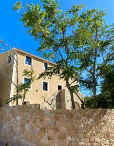 利勒鲁斯Casa u fornu Residence & Spa的一座石头墙后面的建筑,有树