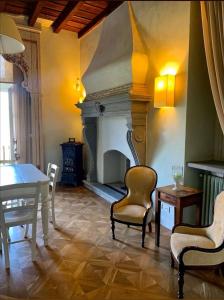 贝加莫B&B Dimora Delle Donnole Bergamo Alta的客厅设有壁炉、桌子和椅子