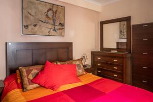 加的斯CASA SALMÓN的一间卧室配有一张带红色和橙色毯子的床