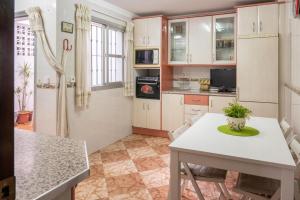 加的斯CASA SALMÓN的厨房配有白色橱柜和桌椅