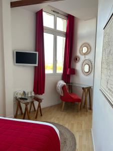 索米尔Rive Gauche的一间卧室设有红色的床和窗户。