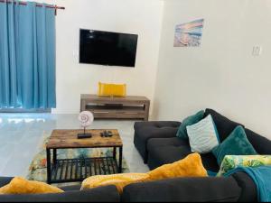 迪斯卡弗里贝Wynters'Escape-gated 1 or 2 Bedroom w PuertoSecoBeach access的带沙发和电视的客厅