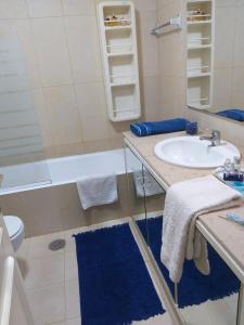 埃斯平霍Avenida 8 apartment的浴室配有盥洗盆、浴缸和盥洗盆