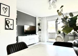 波恩Stilvolles Apartment in Bonn的一间带电视和桌子的客厅