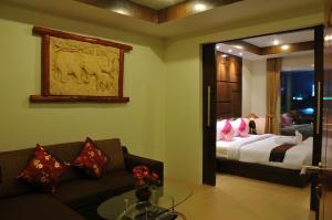 查汶本油芒现代公寓酒店的客厅配有一张床和一张沙发