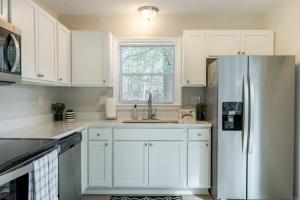 夏洛特Stunning SouthPark/Cotswold Home的厨房配有白色橱柜和不锈钢冰箱