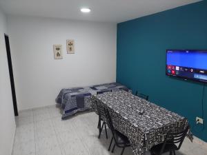 圣罗莎El descanso的一间设有两张桌子的房间和墙上的电视