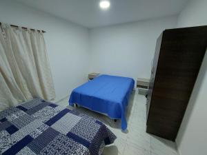 圣罗莎El descanso的一间卧室配有蓝色的床和镜子