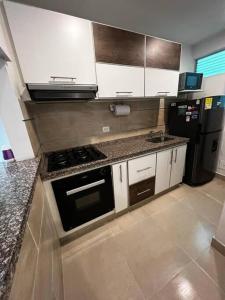 亚美尼亚Charming Apartment Northern Armenia的厨房配有炉灶和冰箱。