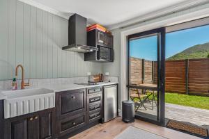 陶波Stagford Retreat Apartment - Taupo的一个带水槽和大窗户的厨房