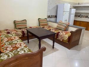 贝尼迈拉勒Appartement Ain Asserdoun的一间设有两张沙发和一张桌子的房间和一间厨房