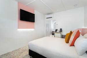 麦凯Bel Air Motel的卧室配有白色的床和平面电视。