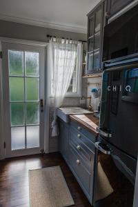 沃洛比Wollombi Wines的厨房配有蓝色橱柜和窗户。
