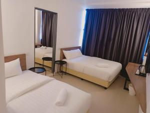 阿罗士打T Hotel Anggerik的酒店客房,设有两张床和镜子