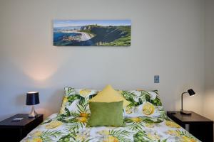 凯库拉Golfer's Retreat的卧室配有一张床,墙上挂有绘画作品