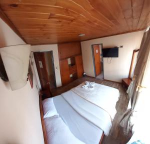 帕斯托Hotel Buenaventura的一间卧室设有两张床和木制天花板