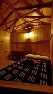 圣佩德罗拉拉古纳Tipis Ya'的一间设有一张床铺的客房,拥有木制天花板