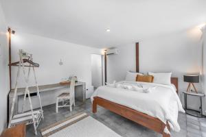 坎古BB Garden Resort的白色卧室配有床和书桌