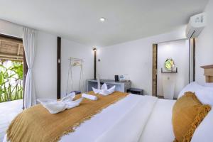 坎古BB Garden Resort的卧室配有一张白色大床和两只白色弓