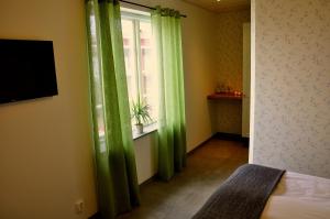 Skurup尼尔斯侯格松斯花园住宿加早餐旅馆的一间卧室设有绿色窗帘和窗户