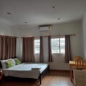 曼谷Happy Hostel的一间卧室设有一张床和两个窗户。