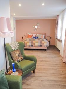 鲁尔河畔米尔海姆Tante ALMA's Mülheimer Hotel的客厅配有绿色椅子和一张床