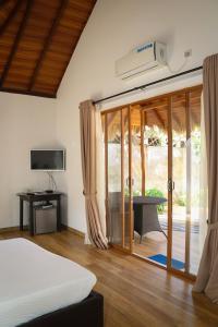 卡尔皮蒂耶The Blue Lagoon Resort Kalpitiya的一间卧室设有一张床和一个滑动玻璃门