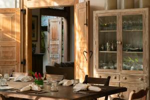 高尔Taru Villas Rampart Street - Galle Fort的一间带桌子和瓷器橱柜的用餐室