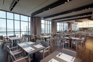 丽水市Shilla Stay Yeosu的餐厅设有桌椅和大窗户。