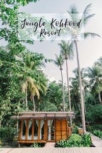 库德岛丛林沽岛度假村 的一座棕榈树成荫的小木结构建筑